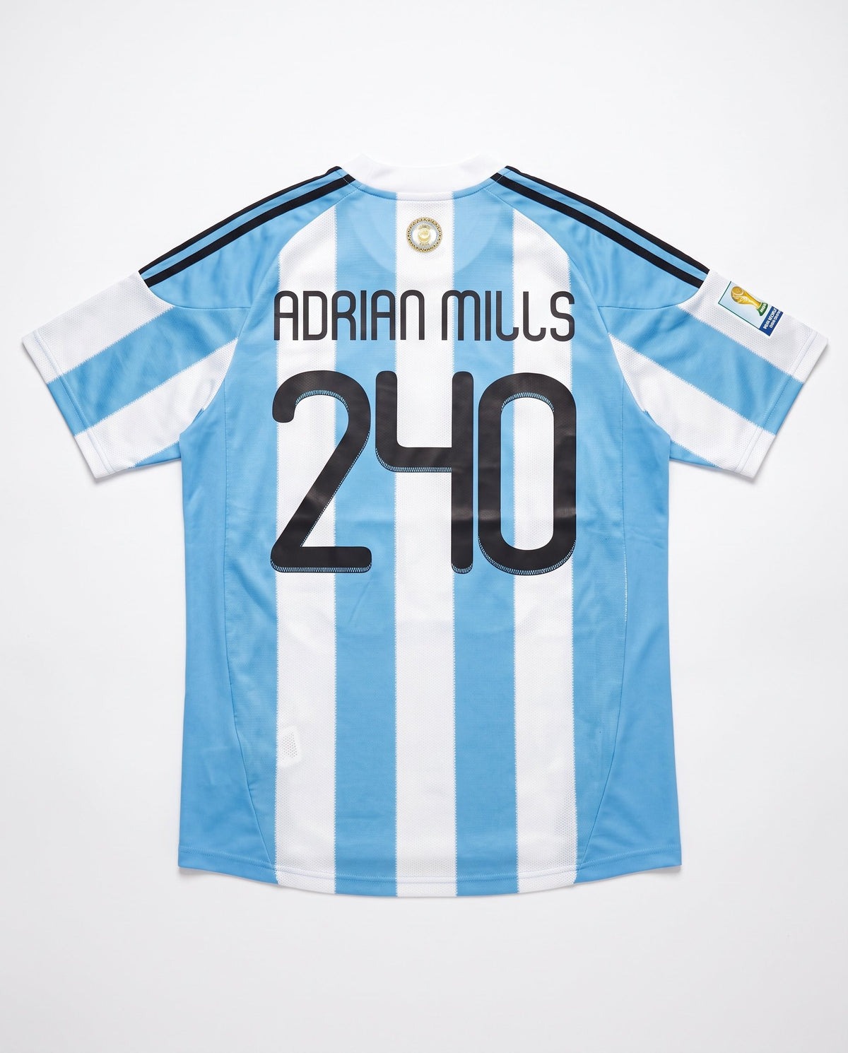 Espalda de la camiseta Argentina celeste y blanca con el nombre Adrián Mills y el número 240 en negro